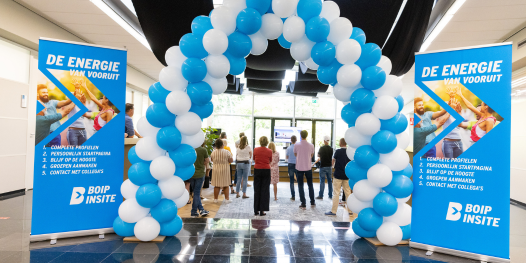 BOIPinsite lancering met collega's die door poort van ballonnen lopen